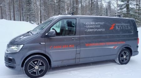 Volkswagen Transporter, kyljessä tekstiä firman palveluista ja puhelinnumero.